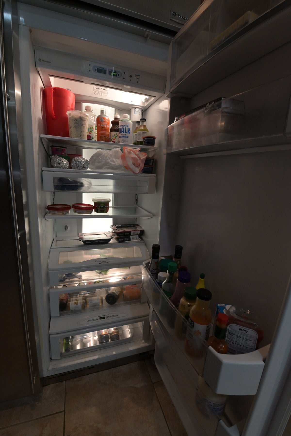 Aurora Circ refrigerator interior with stocked glass shelves crisp drawers and door bins filled with milk bottles condiments and beverages