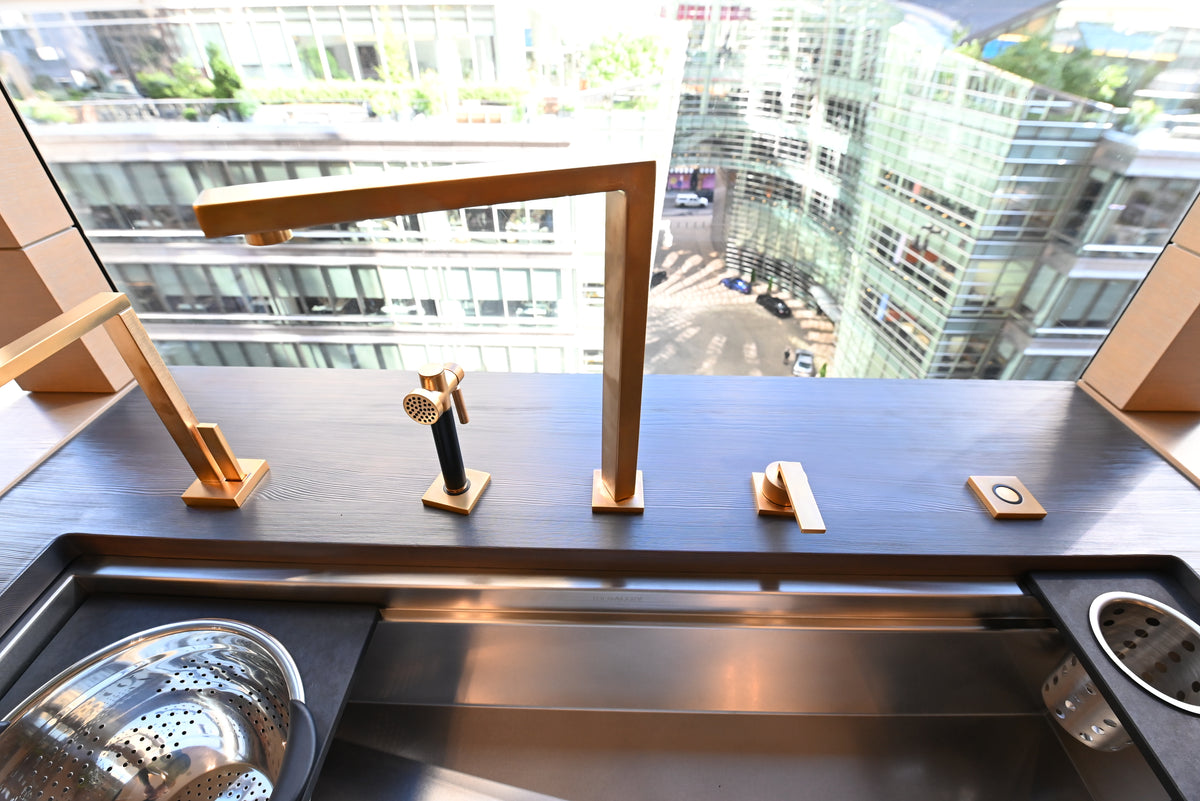 Luxury showroom display kitchen sink and premium gold plumbing fixtures