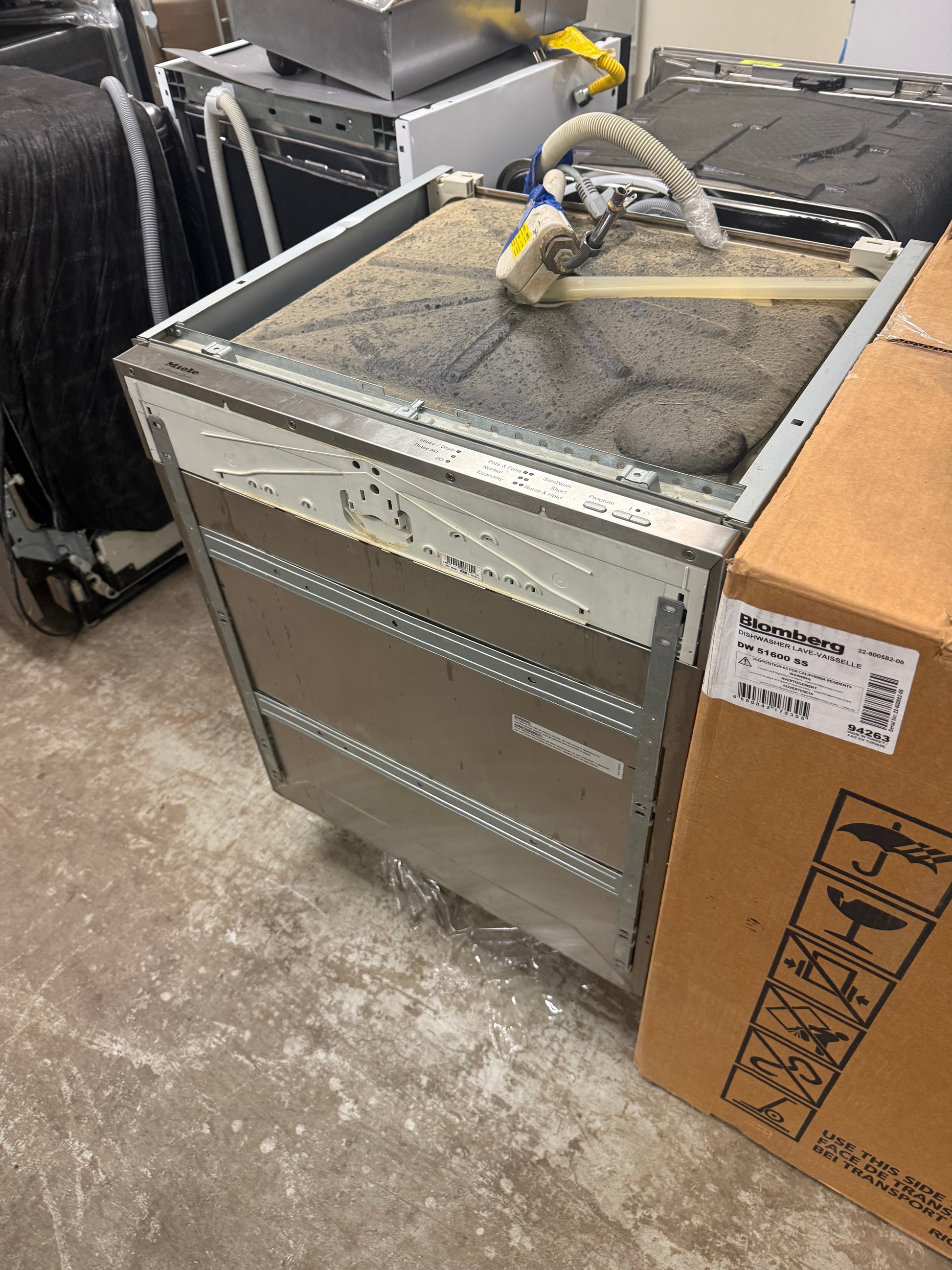 Luxury 24 inch integrated panel dishwasher open showing separate third cutlery tray and stainless steel tub