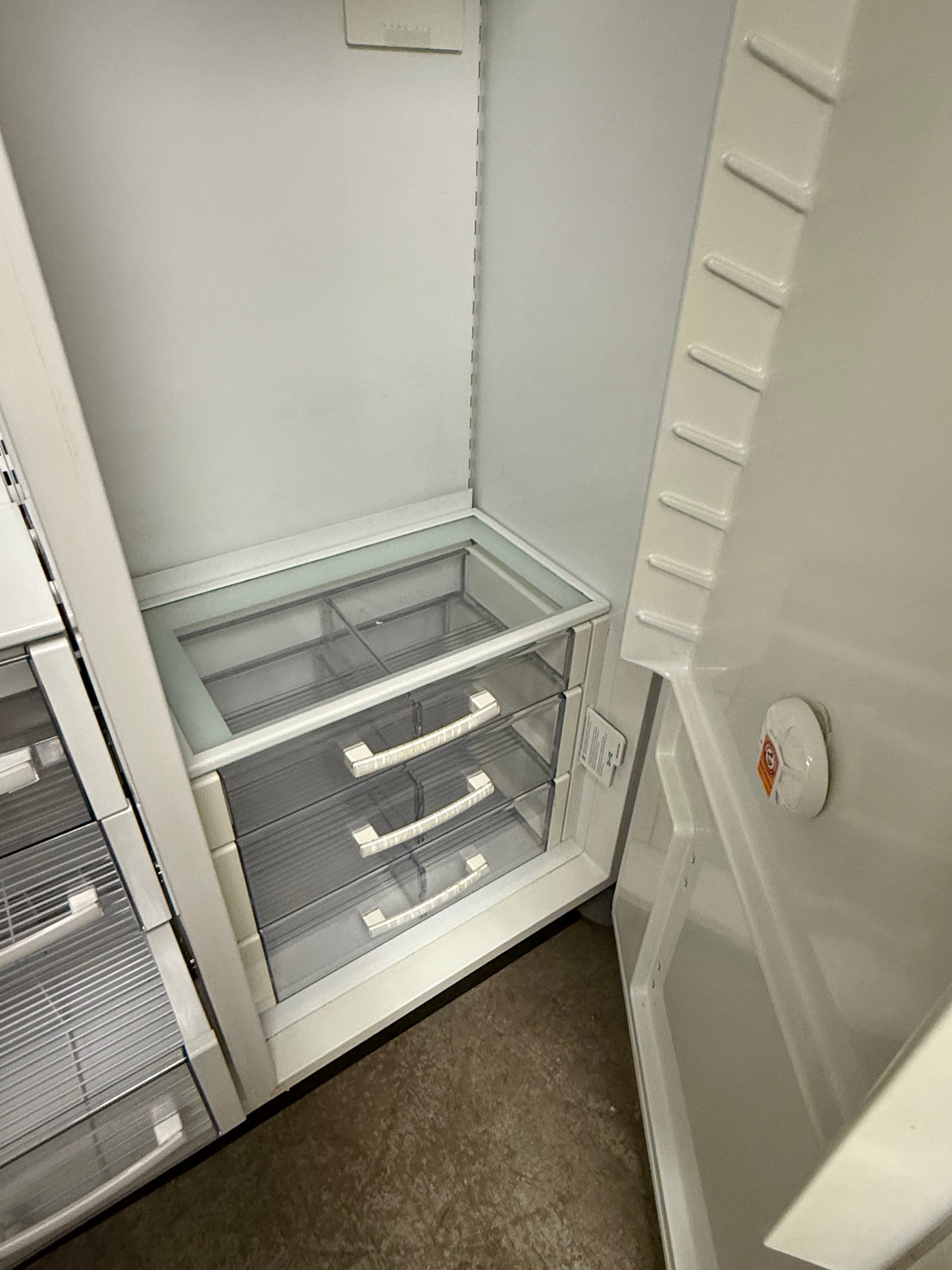 Pre owned Sub Zero 48 inch side by side refrigerator interior detail showing flush wall internal water dispenser