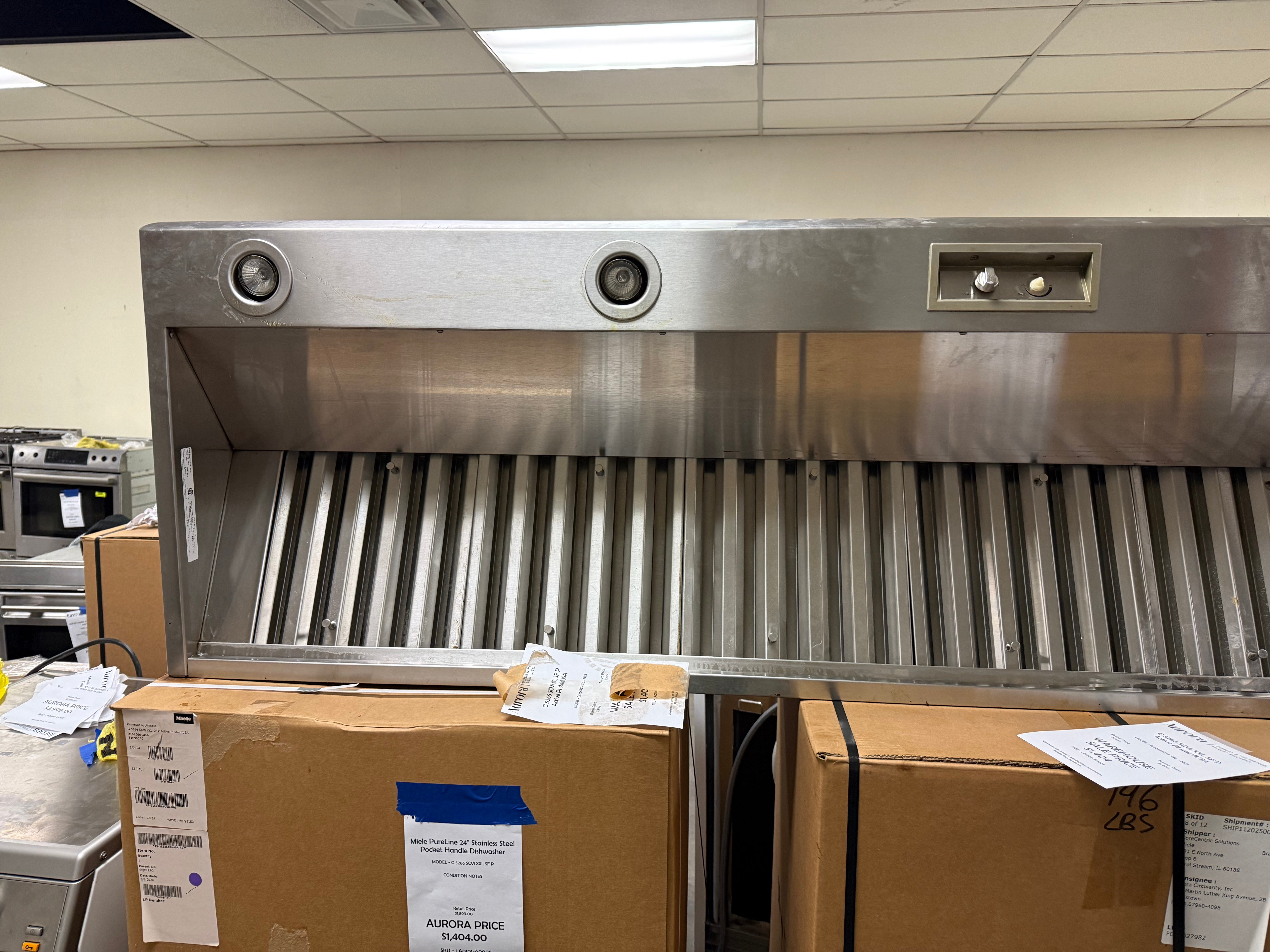 Pre owned Wolf 66 inch professional wall hood installed over high end 60 inch dual fuel cooking range wall setup
