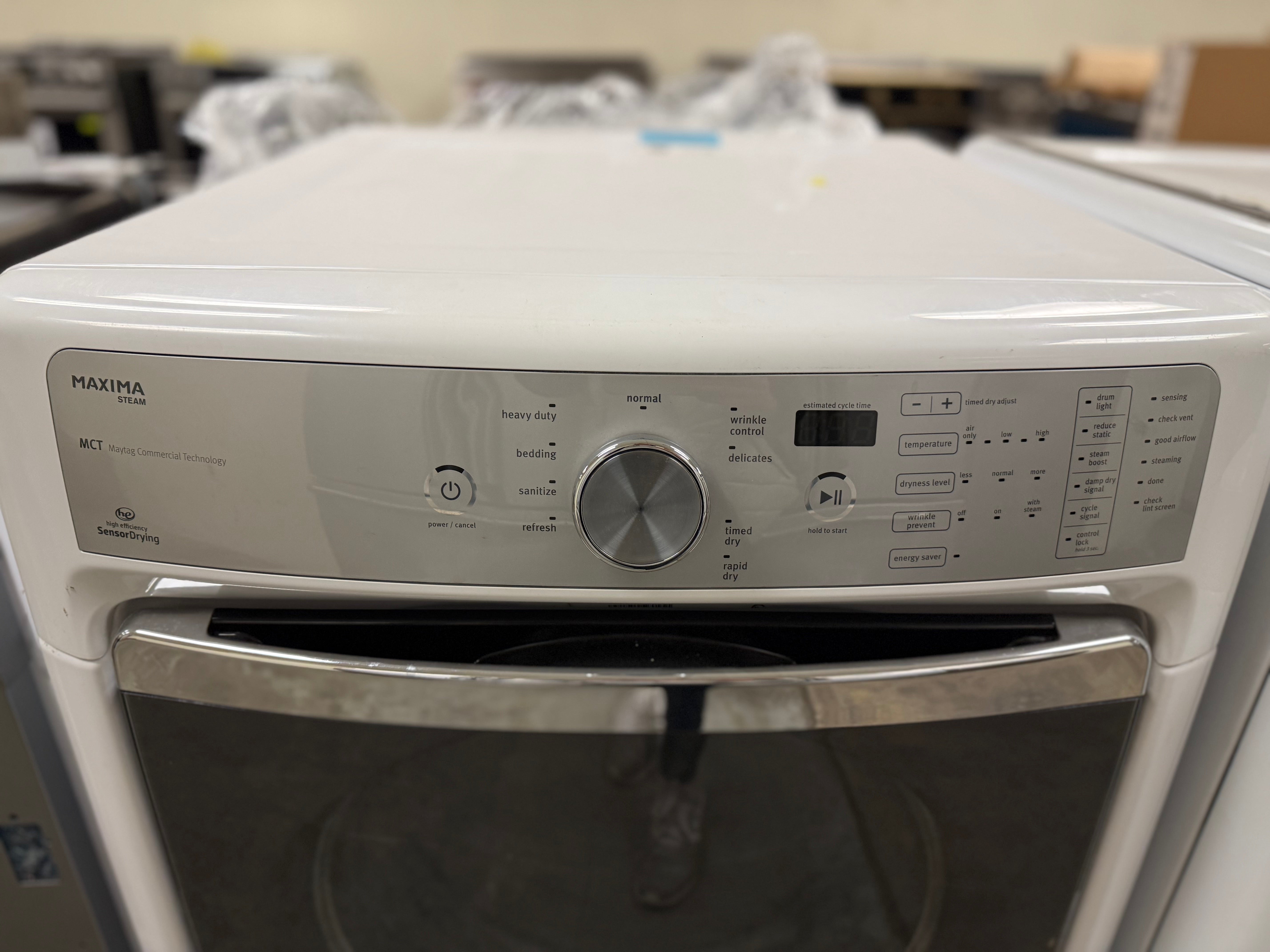 White oven with silver handle and control panel in a warehouse setting