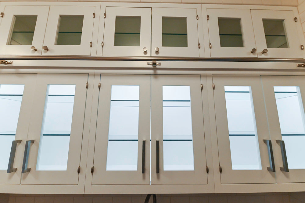 Kitchen cabinets with glass panels and metallic handles.