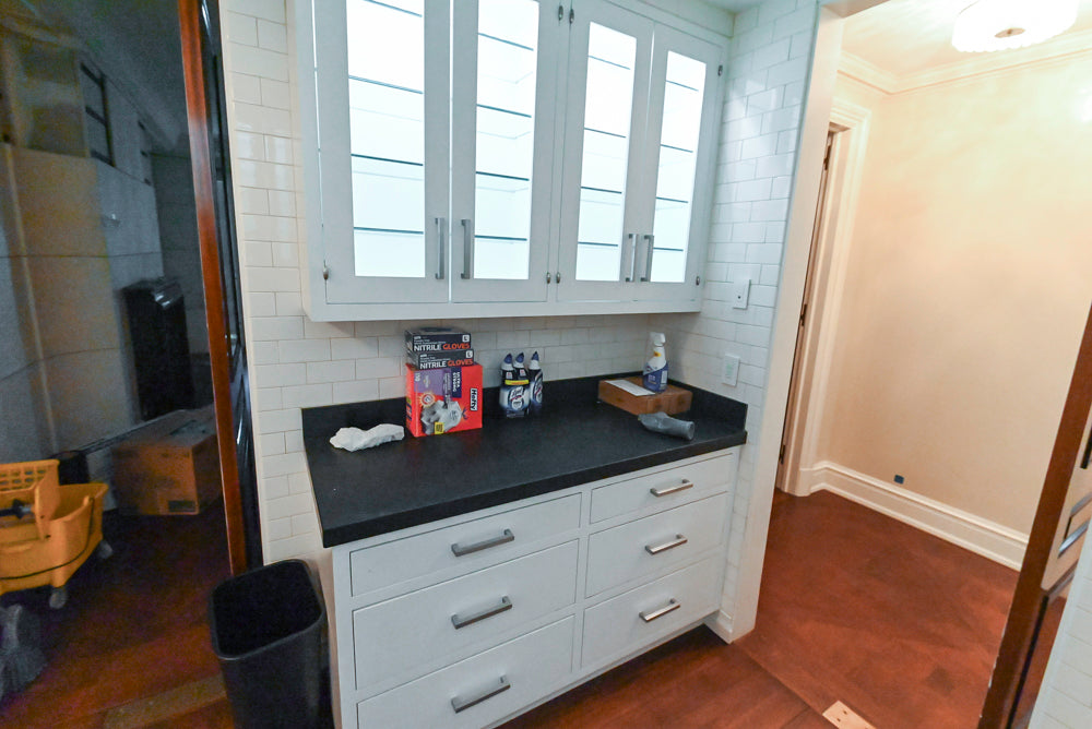 white cabinets, black countertop, and various items on the counter.