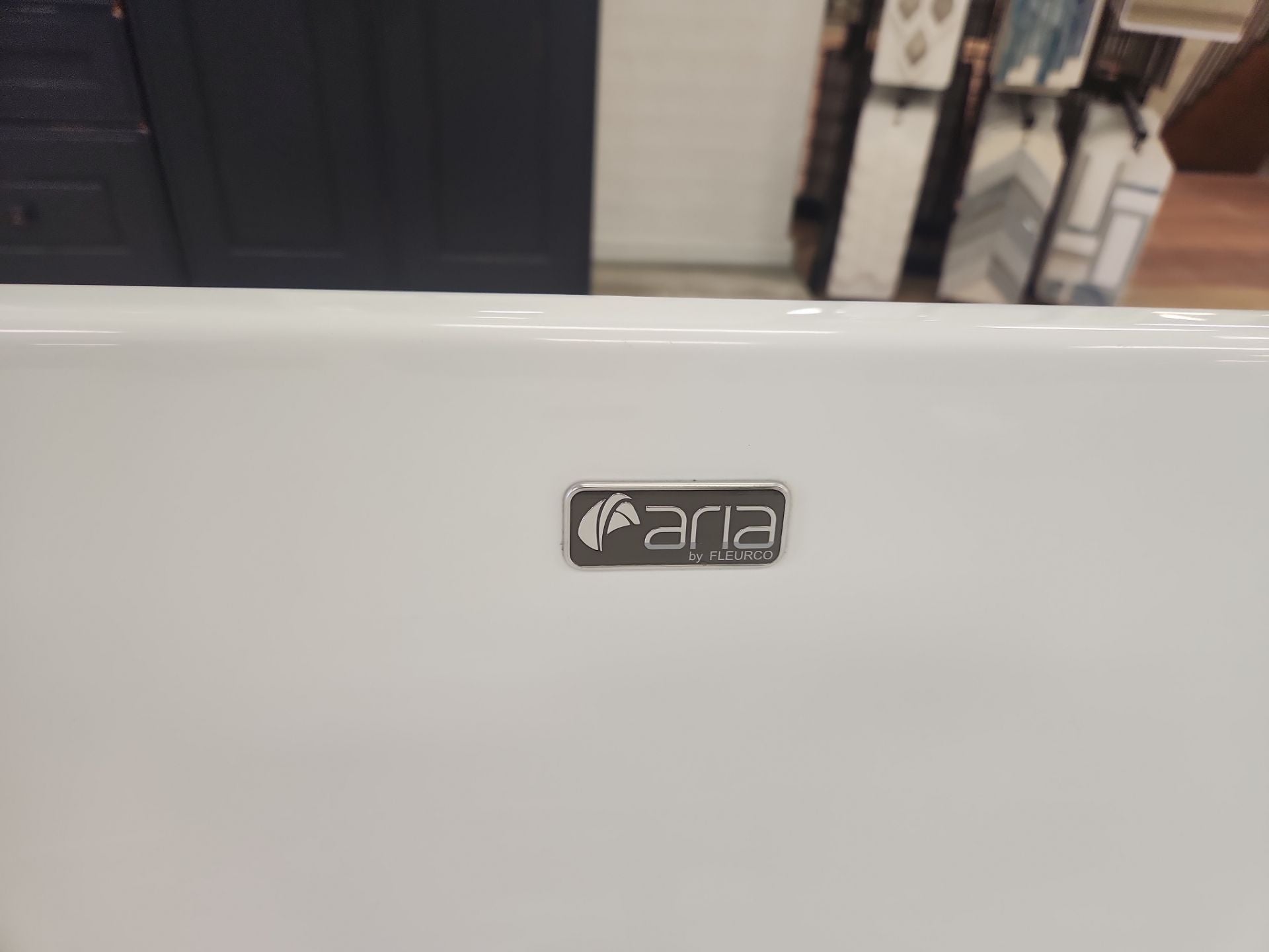 Luxury spa bathroom suite featuring modern white acrylic tub and stainless steel filler