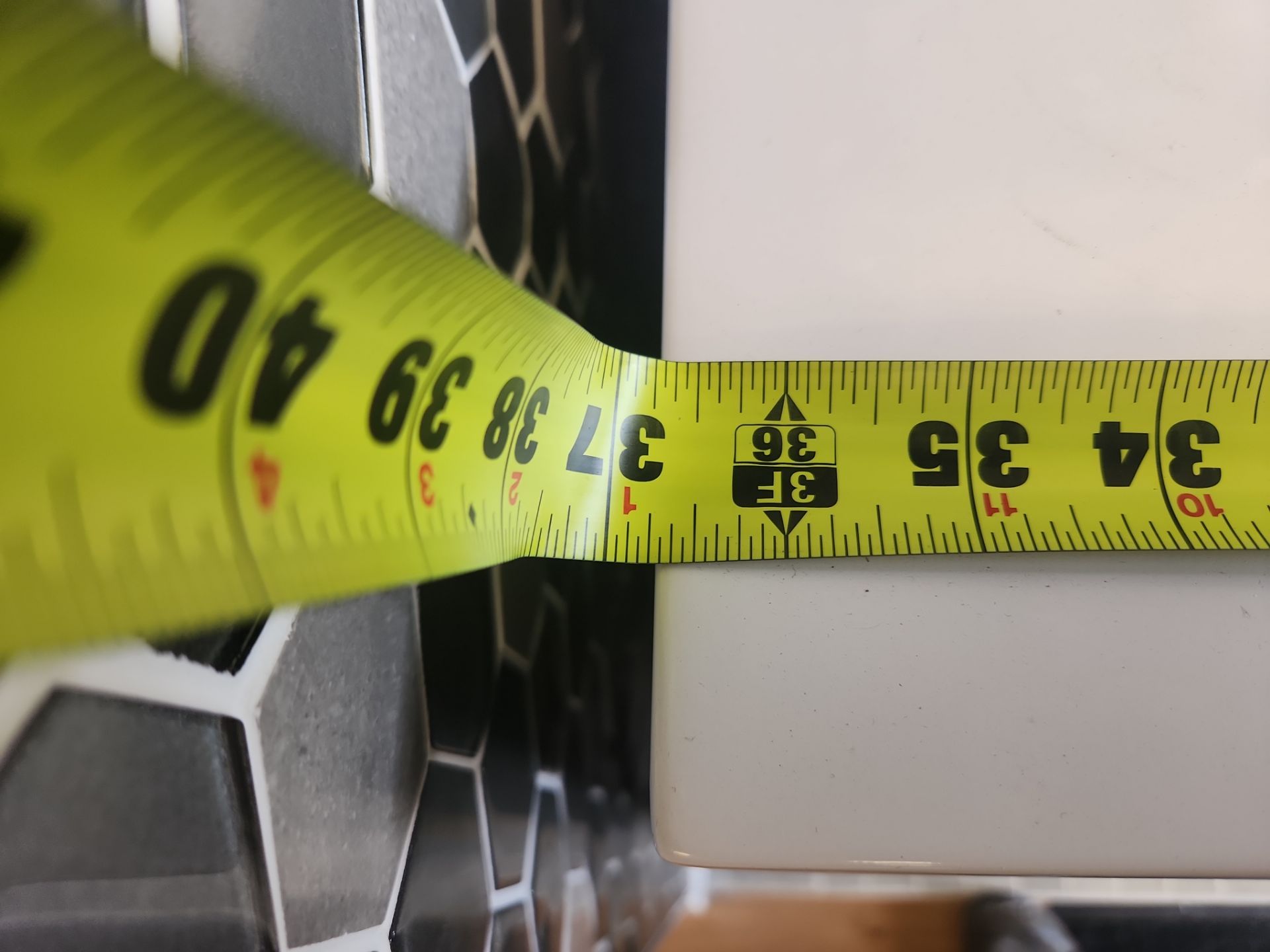 Yellow measuring tape with black text on a white surface