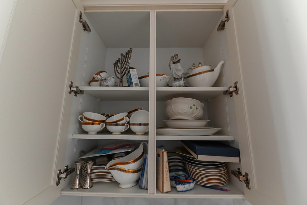 Open cabinet with various ceramic items inside