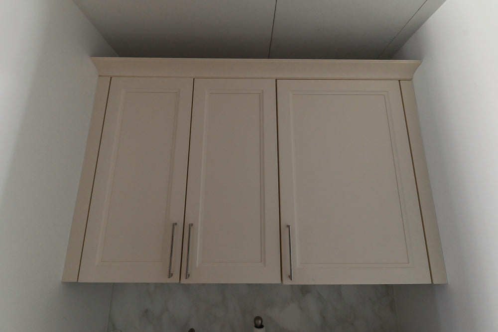  kitchen cabinet with two doors and two handles on a white wall.
