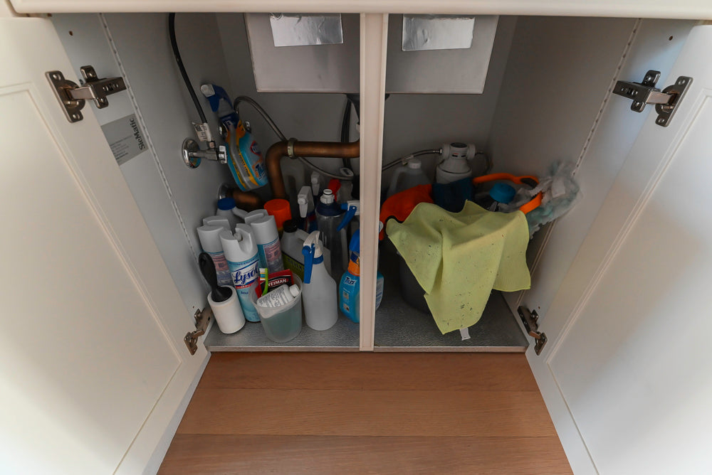 Open cabinet with cleaning supplies inside