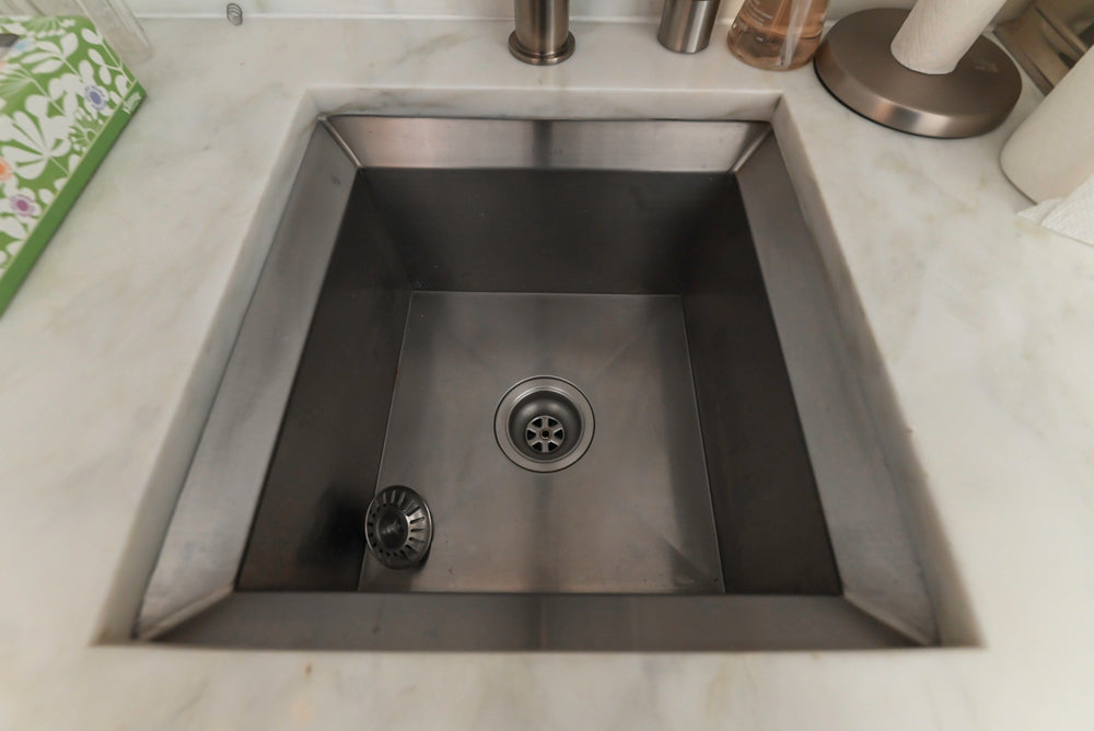 Stainless steel kitchen sink on a marble countertop