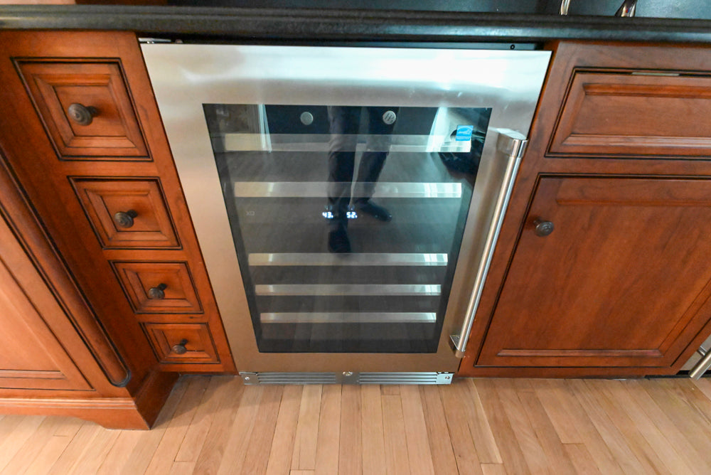 High-end wood cabinetry beverage station with built-in wine fridge and faucet