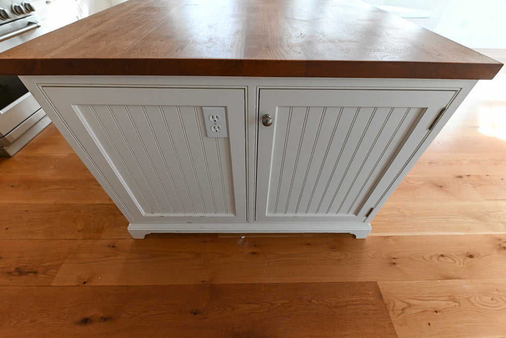 Wooden kitchen island with white base cabinet on a wooden floor