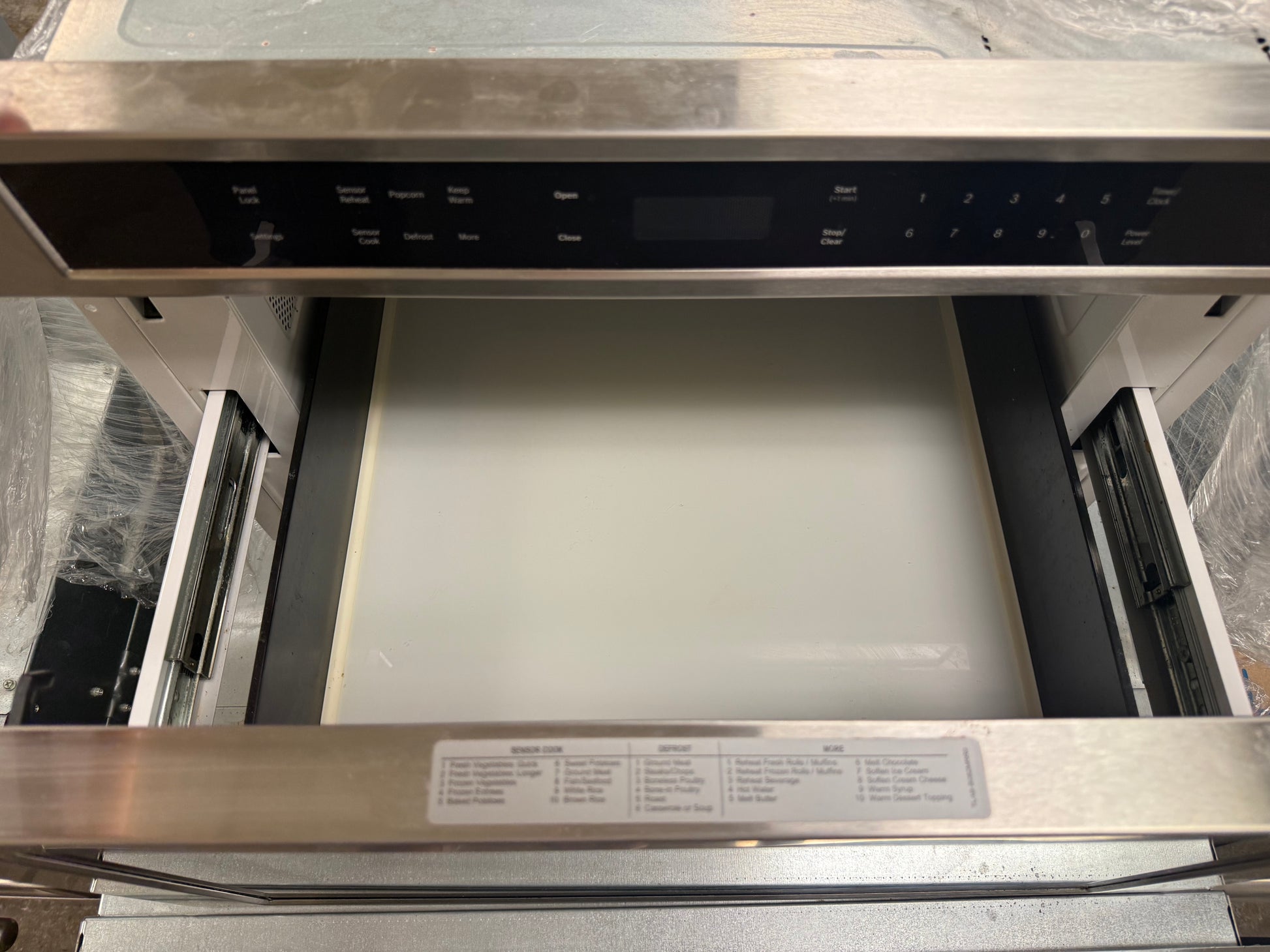 Pre owned Bosch 24 microwave drawer showing glass touch control panel and bright white LCD display