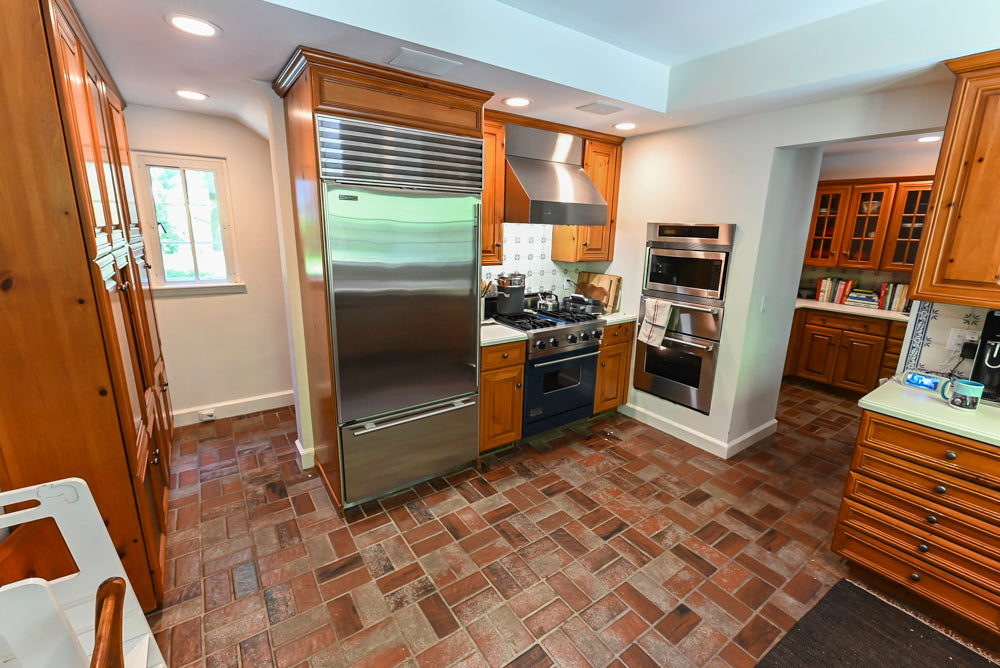 Pre-owned craftsman style kitchen cabinetry with high-end appliances