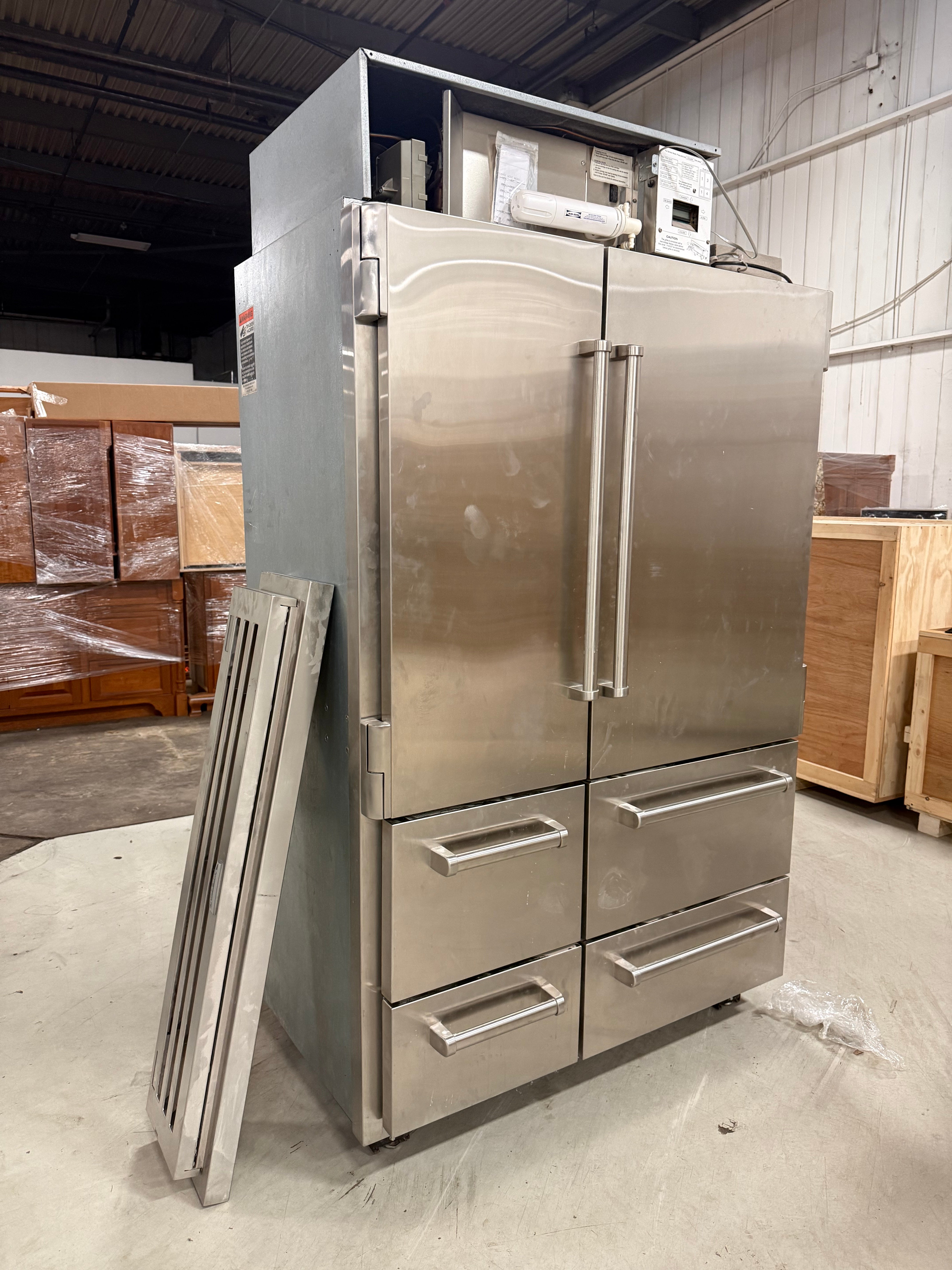 Pre owned Sub Zero PRO series 48 inch solid door refrigerator open showing glass front interior drawers and shelves