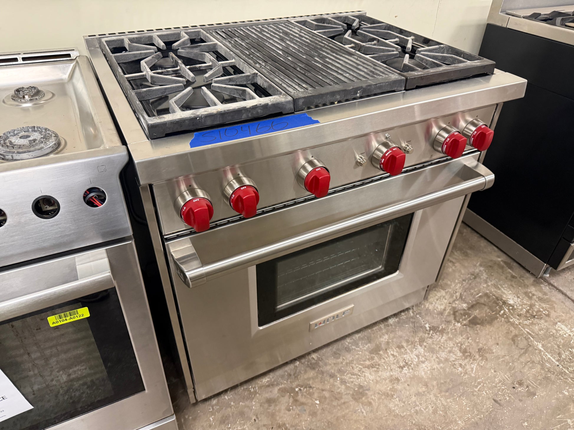 Luxury professional 36 inch gas range cooktop showing four burners and central infrared charbroiler grate
