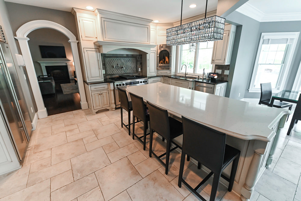 Large kitchen island with granite countertops in a traditional white pre-owned kitchen