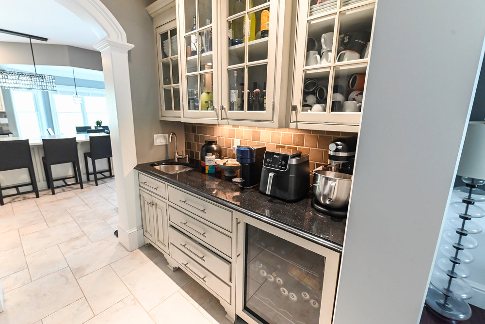 Luxury inset white cabinetry bar with glass display doors and integrated refrigerator