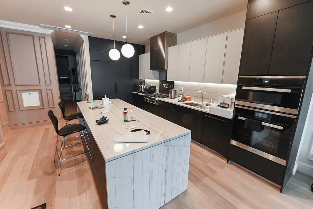The Soho modern two tone high gloss black and white luxury kitchen cabinetry package with waterfall island and integrated appliances