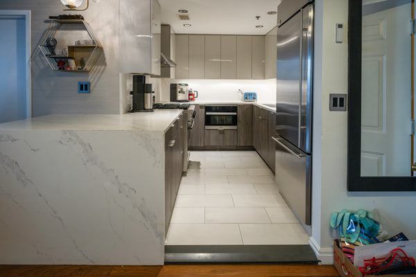 Aurora Circ modern gray two-textured kitchen with a veined quartz island stainless steel appliances and streamlined cabinetry