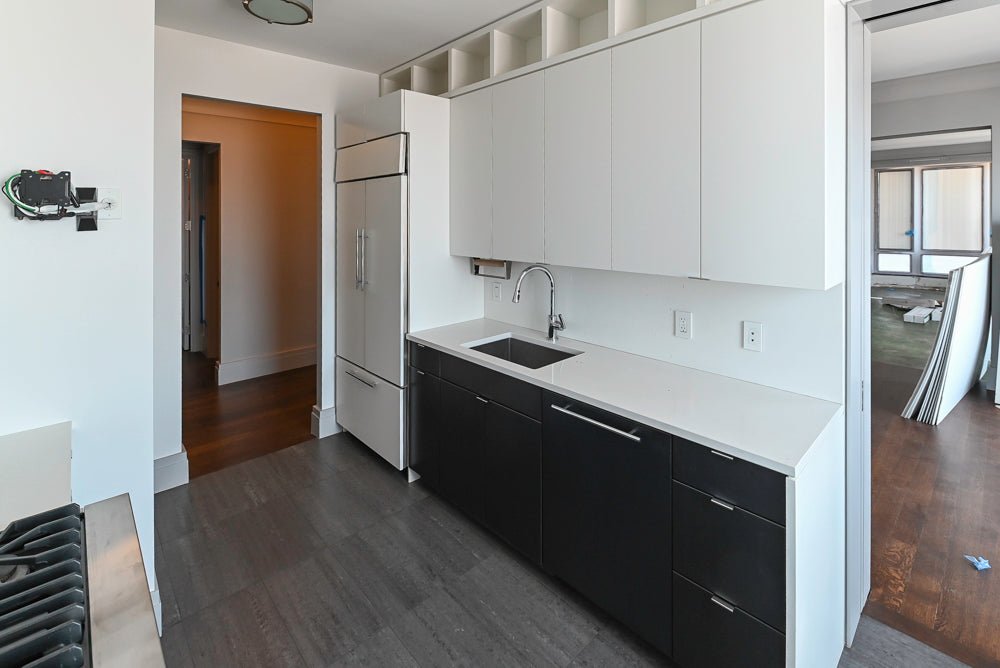 Modern minimalist kitchen cabinets showing matte white upper cabinets and matte black handleless base drawers