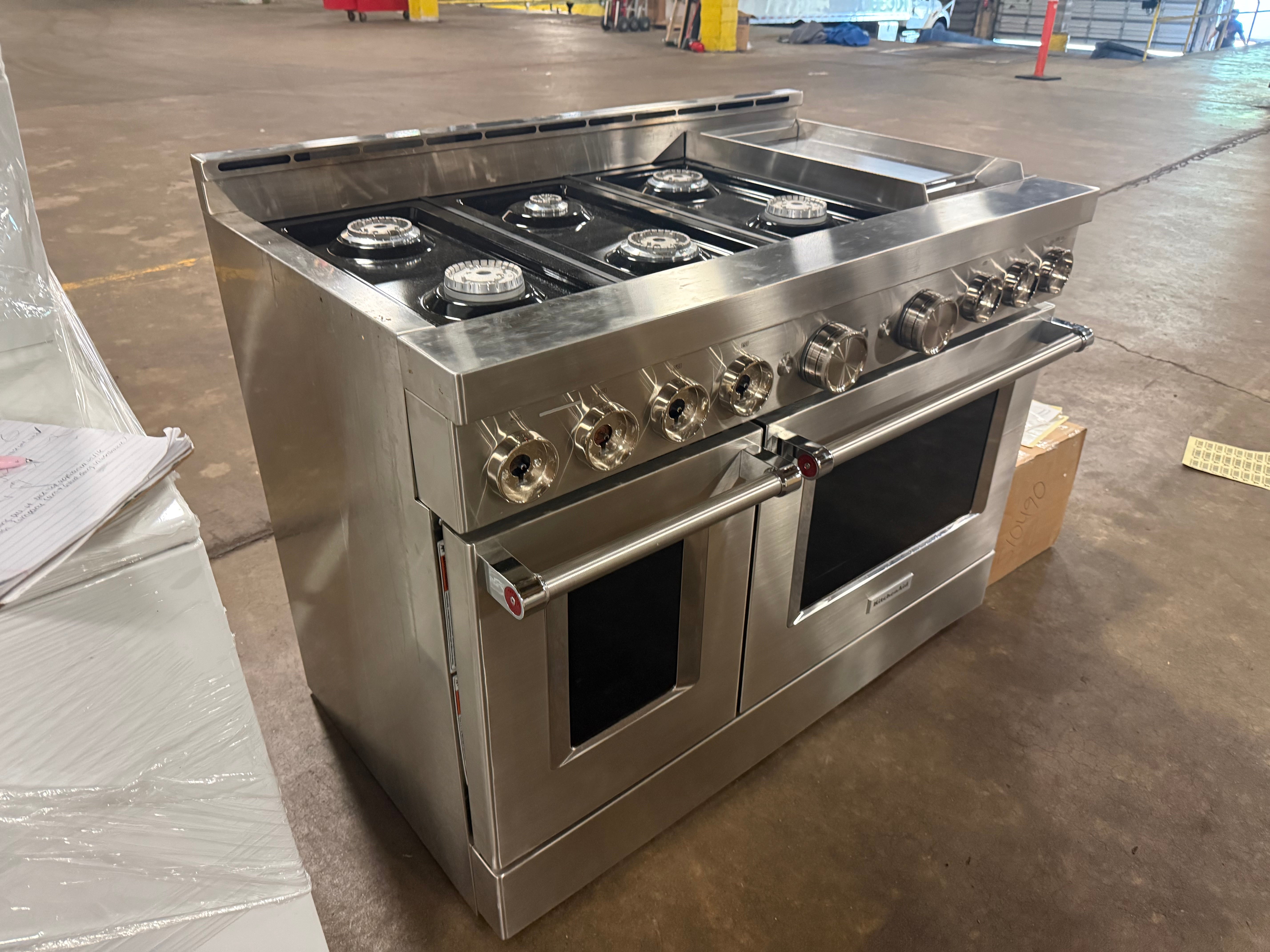 Luxury professional 48 inch gas range cooktop showing six burners and central chrome griddle