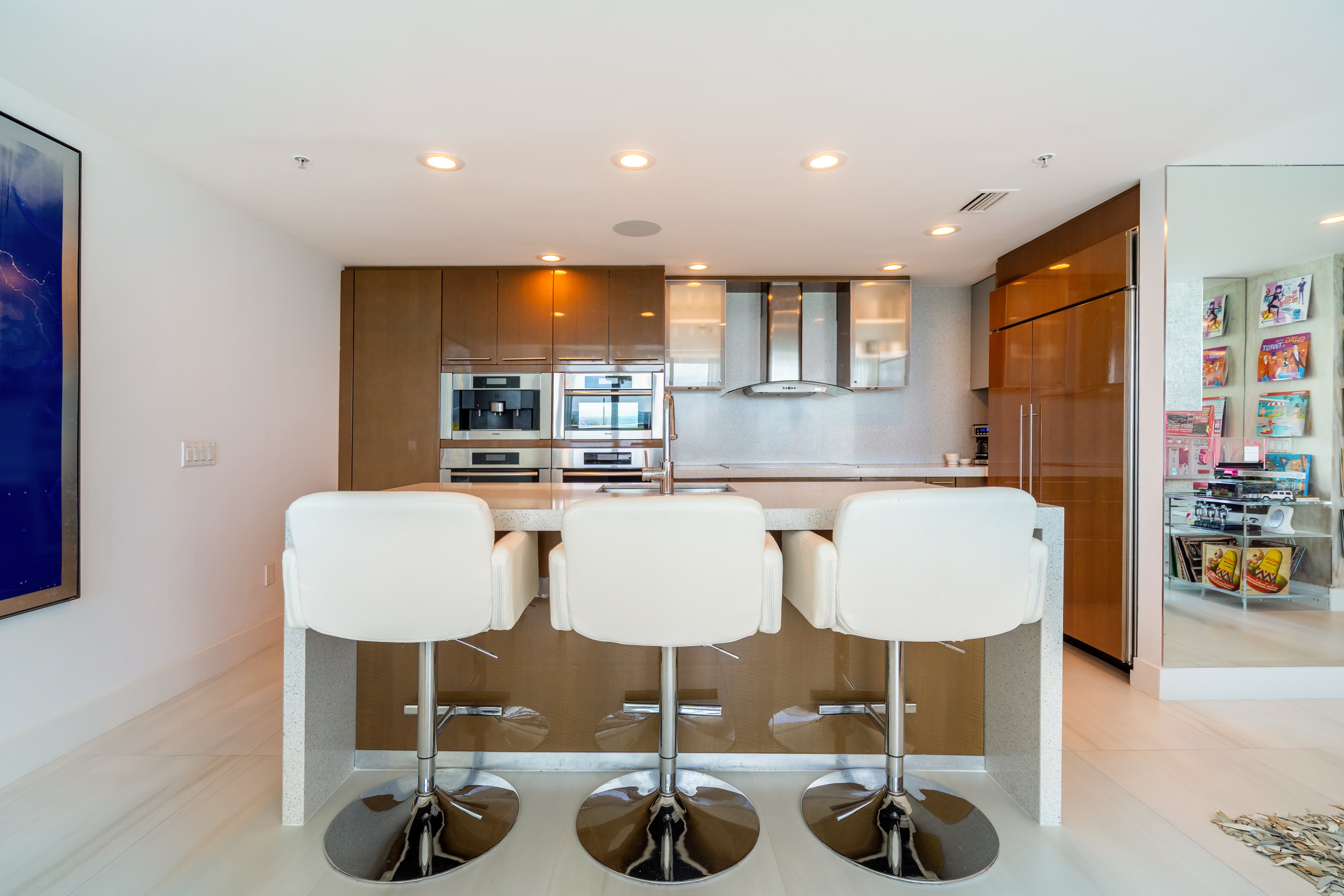 Luxury kitchen island with exotic wood cabinetry and stone countertops