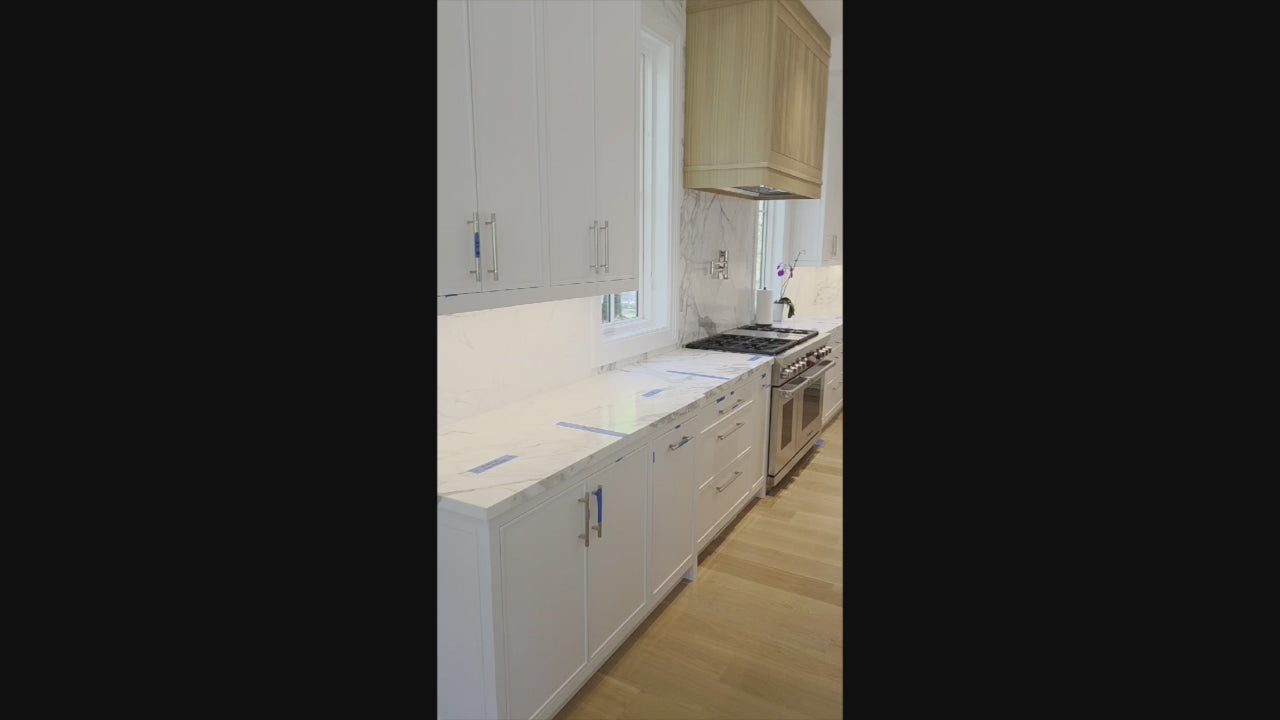 Load video: Custom Transitional White Kitchen with Natural Wood Toned Island, White Marble Countertops and 48&quot; Wolf Range