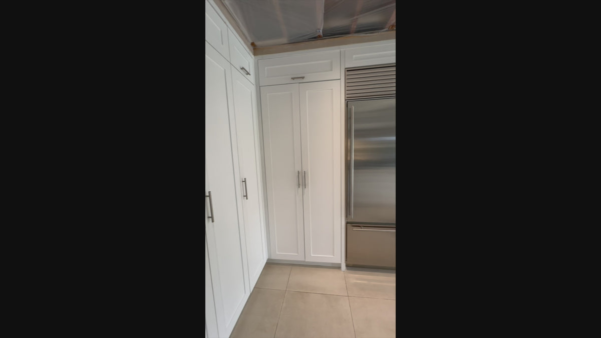 Load video: Luxury showroom display custom white kitchen cabinetry and storage layout