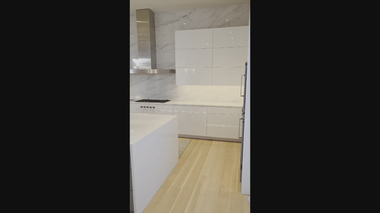 Load video: Brubaker Modern White Lacquered Kitchen with Waterfall Island and Stone Countertops
