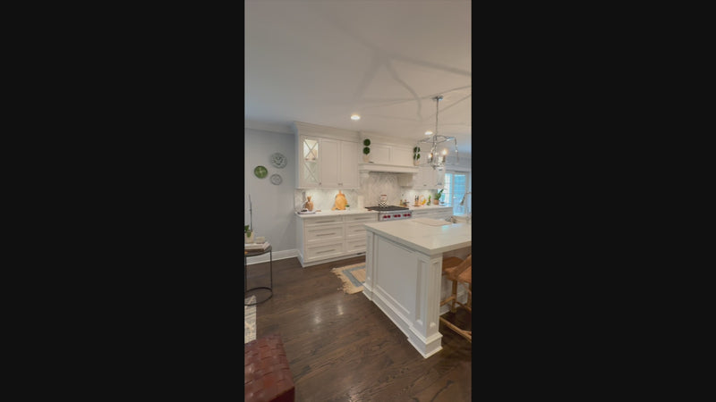 The Claridge transitional white kitchen cabinetry and central island with Wolf appliances