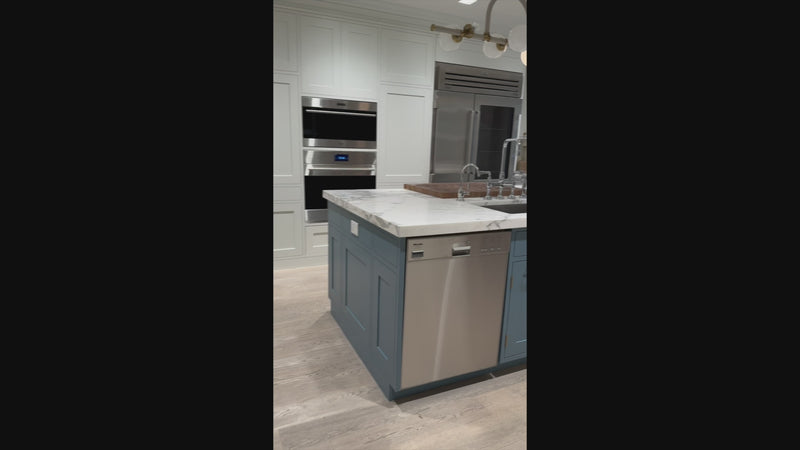 The Windermere transitional white custom kitchen featuring shaker cabinets, a quartz-topped island, and a Sub-Zero 648PROG glass door refrigerator