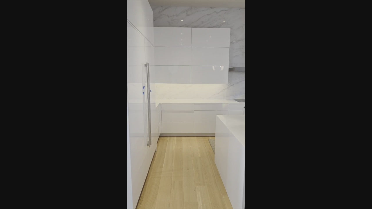 Load video: Brubaker Modern White Lacquered Kitchen with Waterfall Island and Stone Countertops